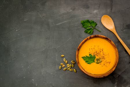 Pumpkin soup - with parsley and seeds - on grey background top view.の写真素材