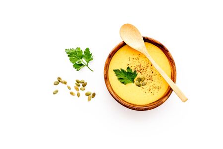 Pumpkin cream soup on white table top view. Autumn traditional meal.の写真素材