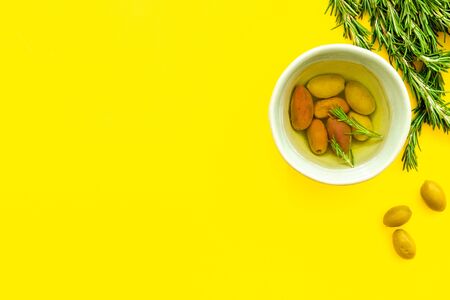 Green olives with oil on yellowの写真素材