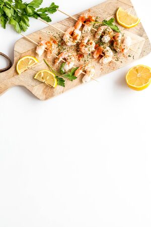 Shrimp skewers on white table