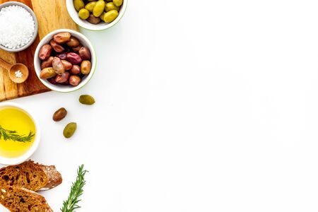 Set of green and res olives with oil on kitchen table.の写真素材
