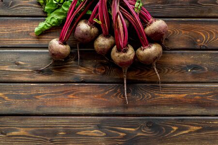 Organic beetroots with green tops and leaves on wooden dark desk. Top viewの写真素材