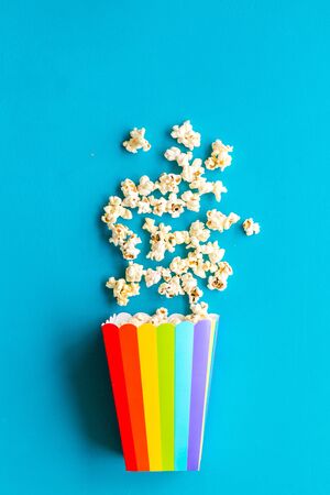 Popcorn in paper cup on blue desk top viewの写真素材