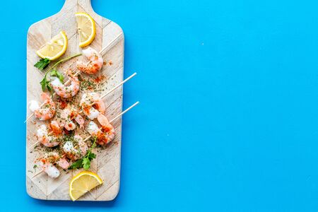 Shrimp skewers - seafood - on blue table top view copy spaceの写真素材