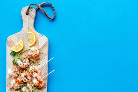 Shrimp skewers - seafood - on blue table top view copy spaceの写真素材