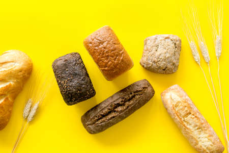 Bakery. Fresh bread in assortment on yellow table top-downの写真素材