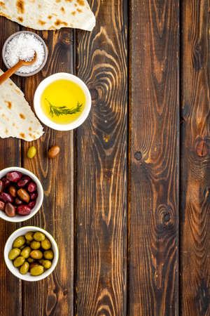 Top view of olives, olive oil, bread on wooden table top view copy spaceの写真素材