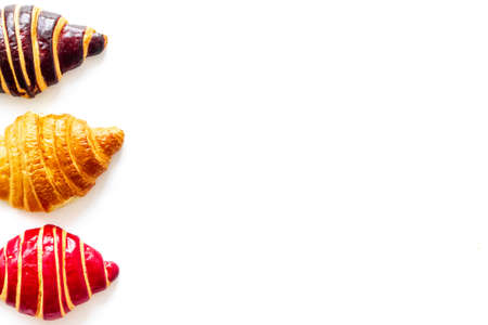 Set of croissants - chocolate, berry, classic - on white background top view.