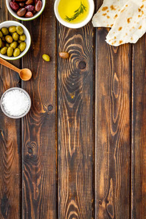 Top view of olives, olive oil, bread on wooden table top view copy spaceの写真素材