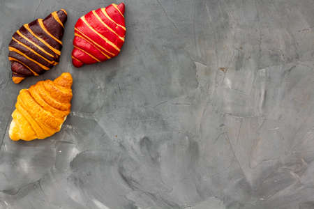 Set of croissants - chocolate, berry, classic - on gray table top view