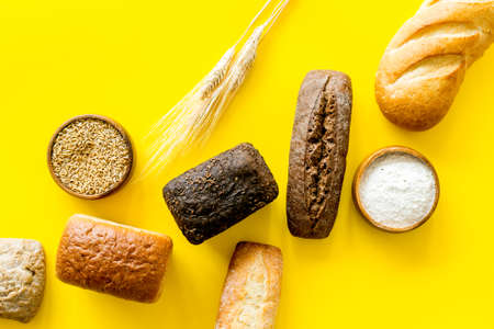 Bakery. Fresh bread in assortment on yellow table top-downの写真素材