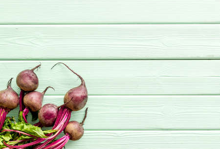 Beet - fresh, with leaves - on green table top view copy space