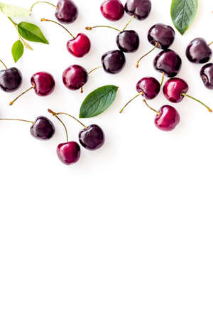 Layout of sweet cherries with leaves, top view, copy space