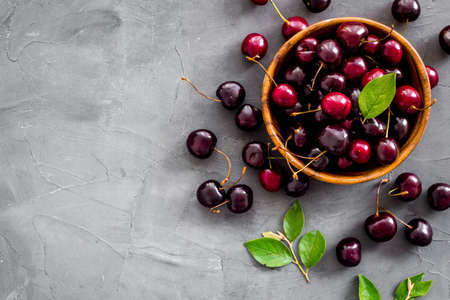 Plate of ripe red cherries with leaves, top viewの写真素材