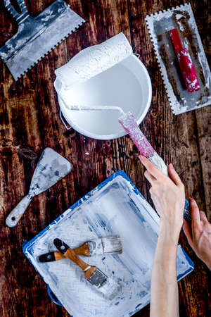 workplace of builder with instruments and paint on wooden background top view