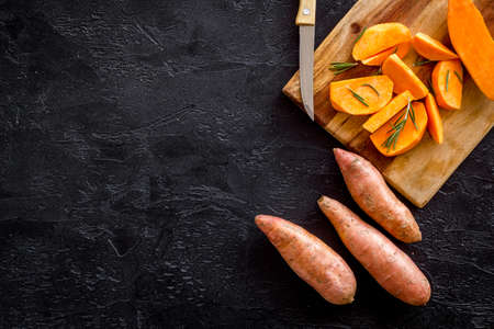 Overhead view of sweet potato sliced on kitchen board. Top view