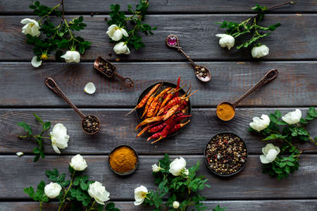 Cooking utensils and hot spices in metal bowls and spoons. Top view