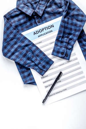 adoption form with clothes in family concept on table top view mock-upの写真素材