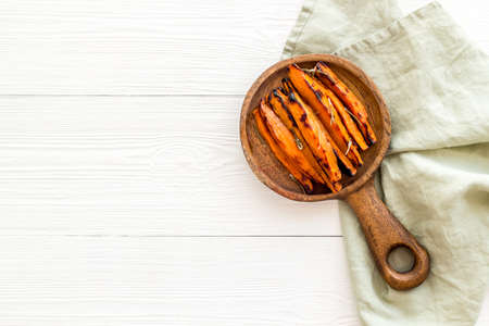 Sweet potato fries with spices on a wooden board, top view