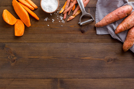 Raw orange sweet potato on cutting board, top viewの写真素材