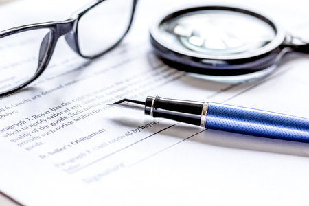 office desk with signing contract, glasses, magnifier and pen for businessの写真素材