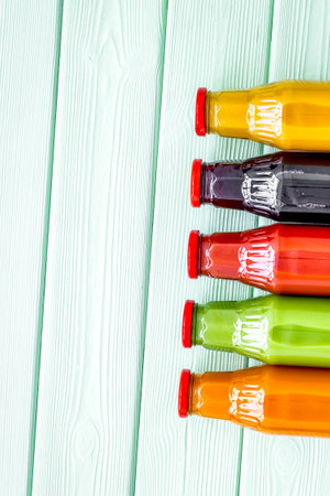 healthy organic juice in bottles for fitness diet and detox on green wooden background top view mockupの写真素材