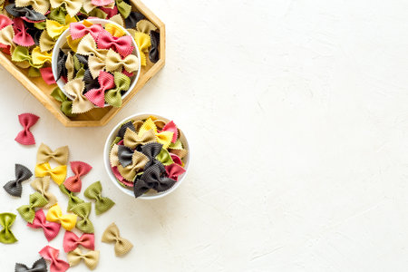 Top view of coloured farfalle pasta in bowlsの写真素材
