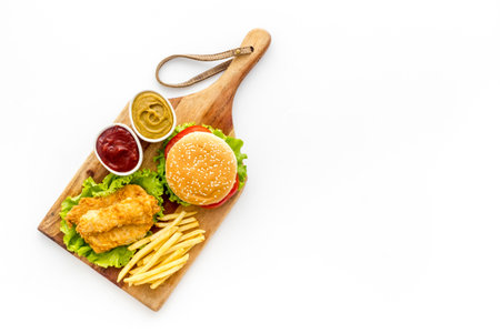 Fast food set. Delicious burger with french fries on wooden cutting boardの写真素材