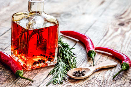 jar with oil and chili on wooden table background