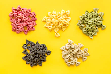 Heaps of pasta - various colors farfalle pasta, top view
