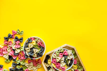 Italian farfalle pasta in bowls. Raw multicolored farfalle pasta, overhead viewの写真素材