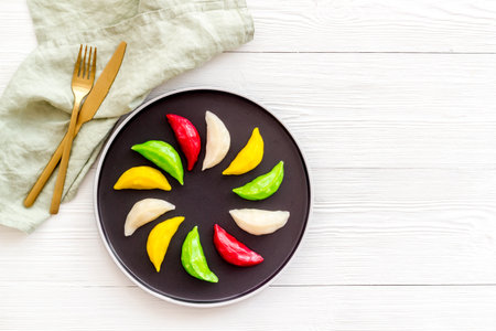 Colourful vegetables dumplings tortellini on black plate, top viewの写真素材
