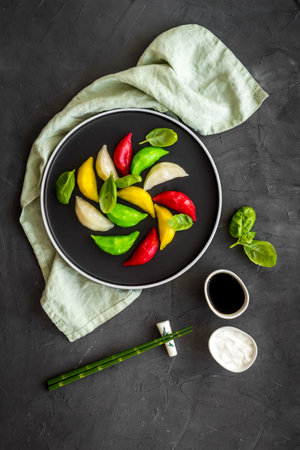 Chinese colourful steamed dumplings on black plate, top viewの写真素材