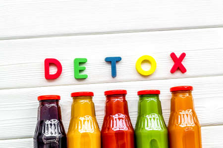 healthy organic juice in bottles for fitness diet and detox on white wooden background top view mockupの写真素材