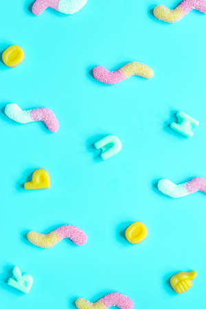 Colorful candies scattered on blue background top view mock upの写真素材