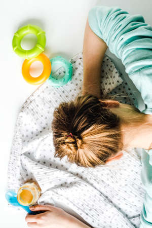 lifestyle tired mother top view on white backgroundの写真素材