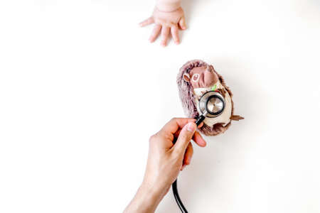 stethoscope, toys and hands on doctors office desk background top view