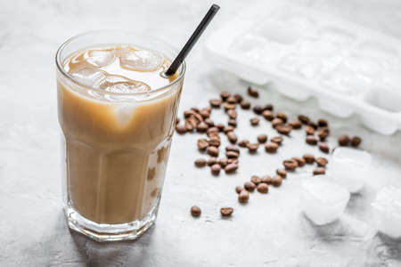 coffee break with cold iced latte and beans on stone table backgroundの写真素材