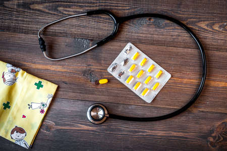 Pediatrics equipment with clothes, medicine wooden background top viewの写真素材