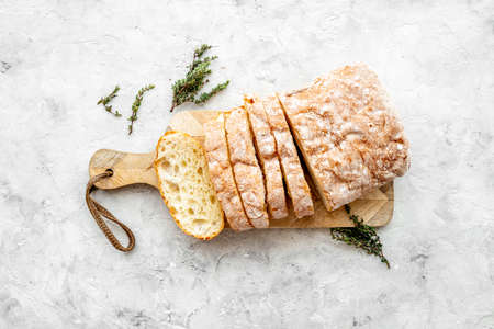 Sliced freshly backed bead ciabatta on cutting board, top viewの写真素材