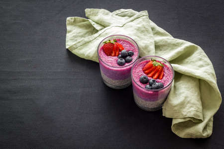 Chia pudding smoothie dessert with strawberries in glass jars. Vegan healthy breakfast.の写真素材