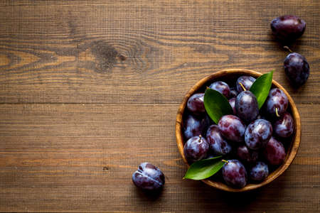 Purple plums in bowl. Plum harvest top viewの写真素材