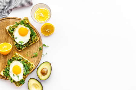 Breakfast with toasts of fried eggs and avocado saurce. Top view