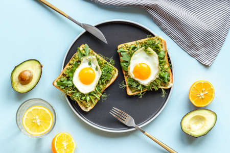 Eggs and avocado with spinach on toasted bread. Top view