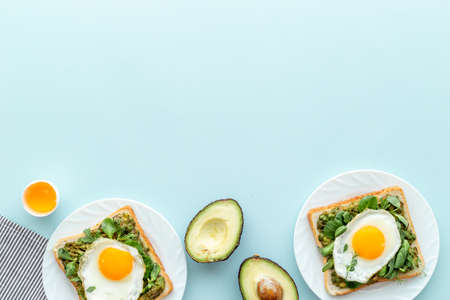 Eggs and avocado with spinach on toasted bread. Top view