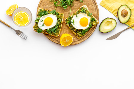 Eggs and avocado with spinach on toasted bread. Top view