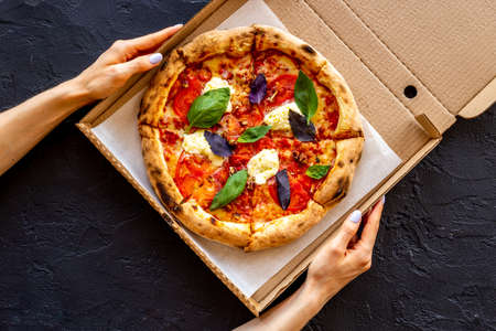 Pizza margarita with tomatoes and basil on the tableの写真素材
