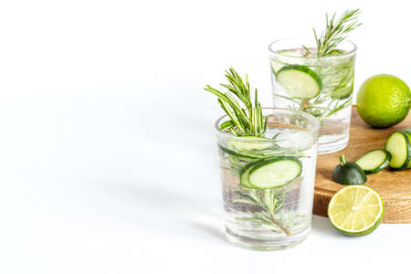 Cold soda drink with pieces of cucumber lime and herbsの写真素材