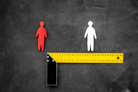 Keep social distance concept with two man figures and metal rulerの写真素材