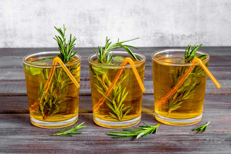 Fefreshing drink of cold tea and rosemary herbs in glassesの写真素材